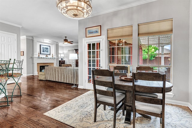 4404 Barnsley Dr, Plano, TX 75093 - dining area with crown molding, ceiling fan, wood finished floors, a fireplace, and a chandelier