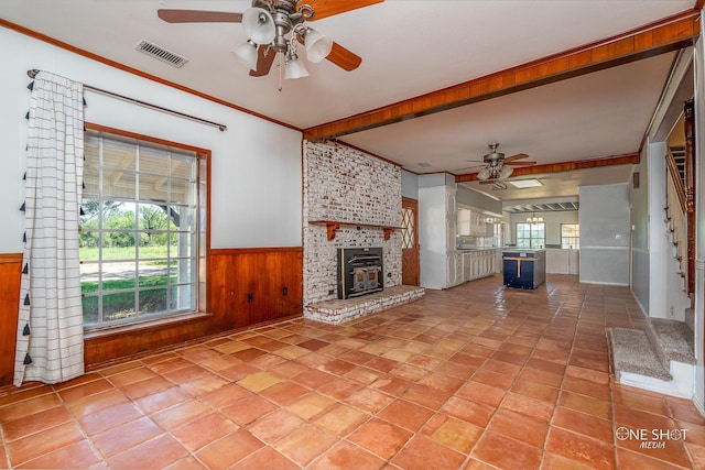 3741 Caldwell Rd, Abilene, TX 79601 - unfurnished living room with a ceiling fan, wood walls, crown molding, a brick fireplace, and wainscoting