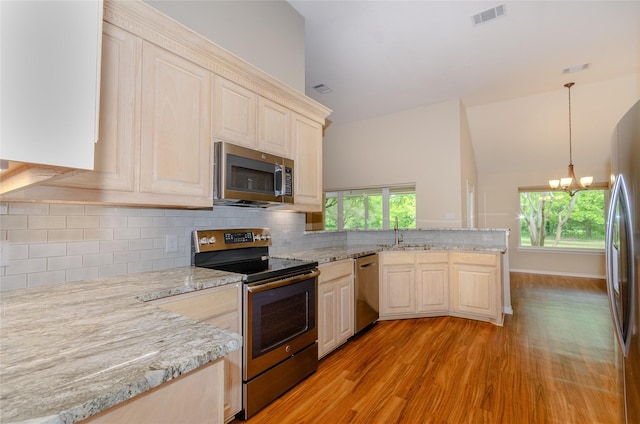 4720 Ashley Cir, Midlothian, TX 76065 - kitchen featuring stainless steel appliances, a peninsula, light wood-type flooring, a chandelier, and light brown cabinetry