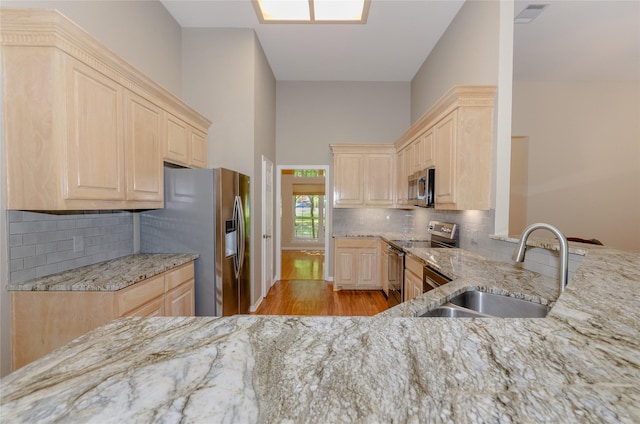 4720 Ashley Cir, Midlothian, TX 76065 - kitchen featuring appliances with stainless steel finishes, light brown cabinets, light stone counters, and a towering ceiling