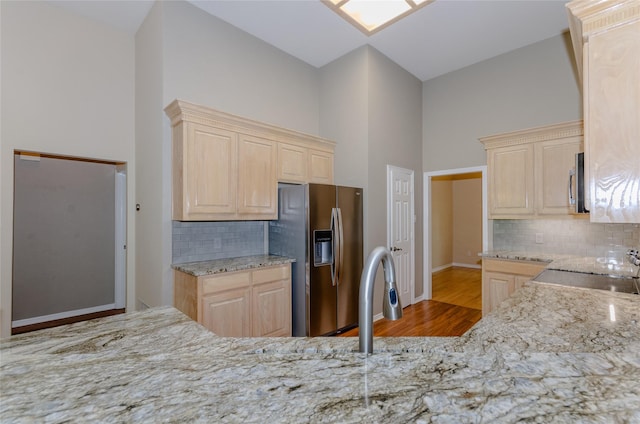 4720 Ashley Cir, Midlothian, TX 76065 - kitchen featuring light brown cabinets, appliances with stainless steel finishes, wood finished floors, light stone counters, and a high ceiling