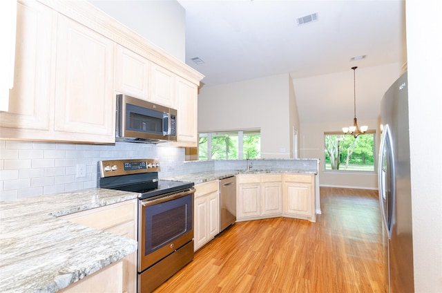 4720 Ashley Cir, Midlothian, TX 76065 - kitchen with stainless steel appliances, light wood-type flooring, a chandelier, a peninsula, and backsplash