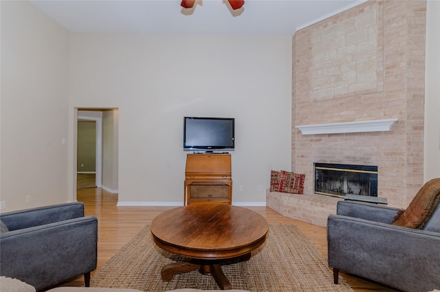 4720 Ashley Cir, Midlothian, TX 76065 - living area with wood finished floors, ceiling fan, a brick fireplace, and a high ceiling