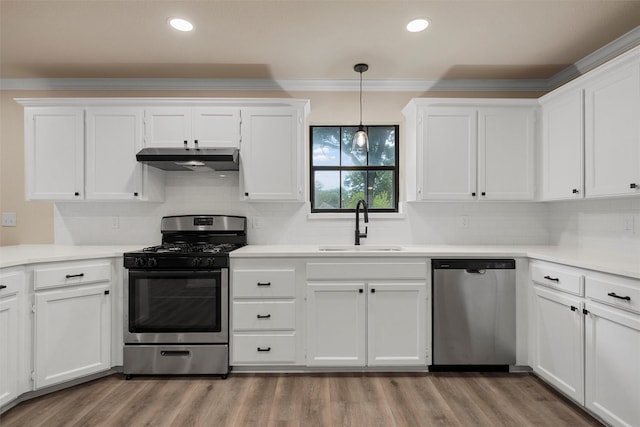 402 2nd St, Moody, TX 76557 - kitchen with stainless steel appliances, under cabinet range hood, white cabinets, ornamental molding, and recessed lighting