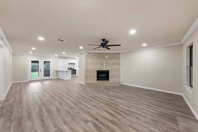 402 2nd St, Moody, TX 76557 - unfurnished living room with ornamental molding, ceiling fan, recessed lighting, light wood-type flooring, and a tiled fireplace