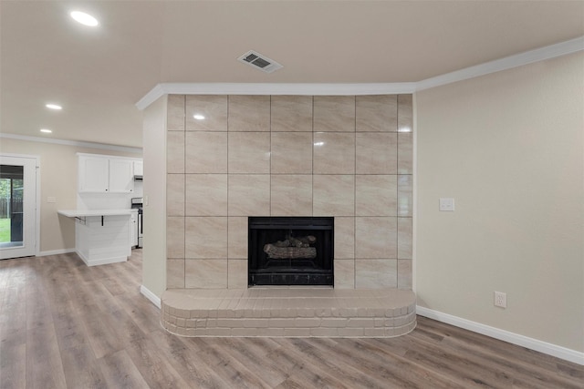 402 2nd St, Moody, TX 76557 - unfurnished living room featuring crown molding, light wood finished floors, a fireplace, and recessed lighting
