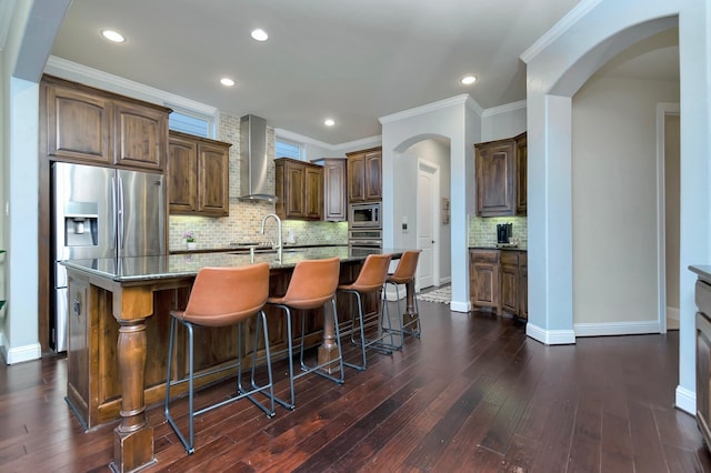 1844 Halifax St, Roanoke, TX 76262 - kitchen with wall chimney range hood, stainless steel appliances, arched walkways, dark wood finished floors, and ornamental molding