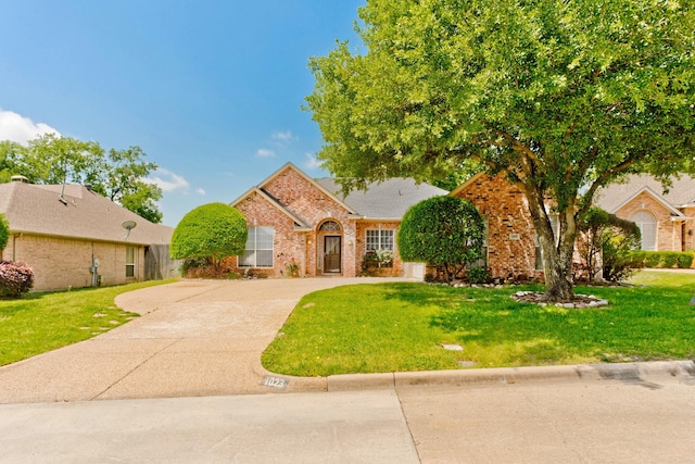 1023 Muirfield Dr, Mansfield, TX 76063 - view of front of home featuring brick siding, a front yard, and concrete driveway