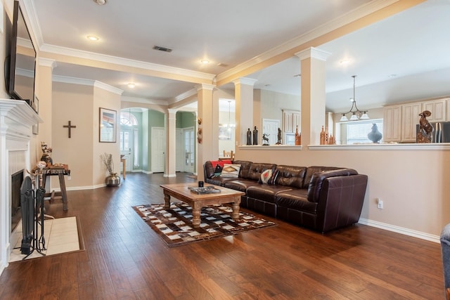 1023 Muirfield Dr, Mansfield, TX 76063 - living area featuring ornate columns, dark wood-style flooring, arched walkways, ornamental molding, and a fireplace