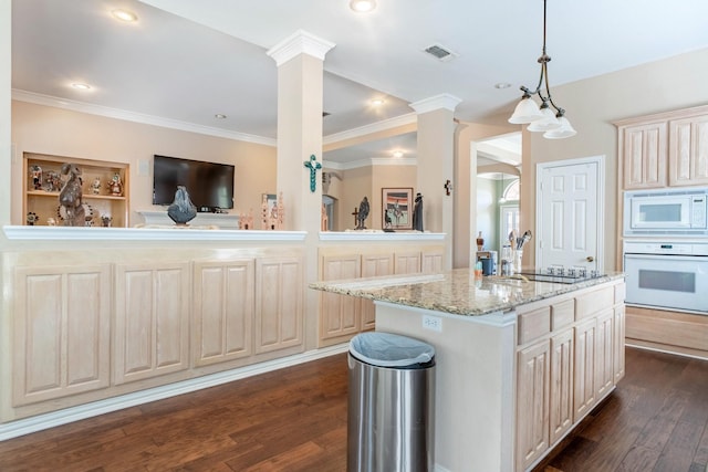 1023 Muirfield Dr, Mansfield, TX 76063 - kitchen featuring white appliances, decorative columns, dark wood-style flooring, light stone countertops, and a kitchen island with sink
