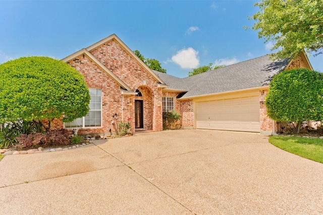 1023 Muirfield Dr, Mansfield, TX 76063 - view of front of house with brick siding, a garage, driveway, and roof with shingles