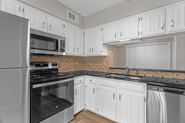 333 Melrose Dr Unit 4D, Richardson, TX 75080 - kitchen with appliances with stainless steel finishes, white cabinets, tasteful backsplash, and dark stone counters
