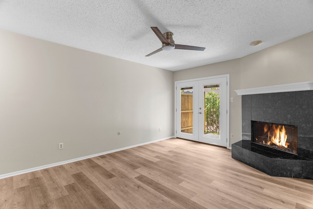 333 Melrose Dr Unit 4D, Richardson, TX 75080 - unfurnished living room featuring french doors, wood finished floors, a fireplace, a ceiling fan, and a textured ceiling