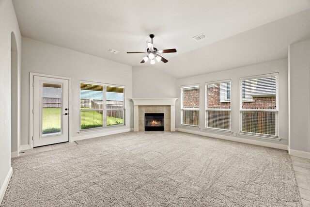 1020 Broken Wheel Trl, Aubrey, TX 76227 - unfurnished living room with ceiling fan, a tiled fireplace, carpet flooring, and vaulted ceiling