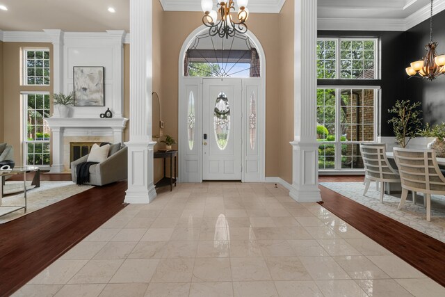 4609 Huffman Ct, Plano, TX 75093 - foyer with a chandelier, ornamental molding, recessed lighting, a glass covered fireplace, and light marble finish floors