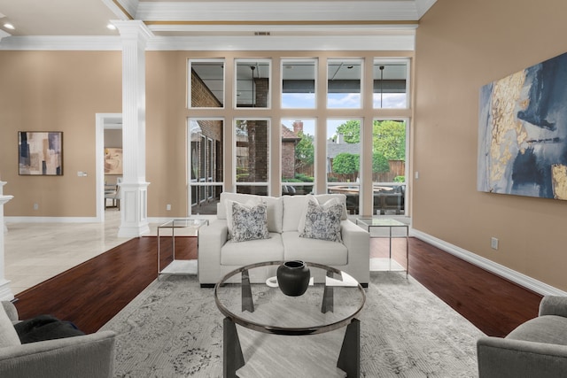 4609 Huffman Ct, Plano, TX 75093 - living area with decorative columns, crown molding, a towering ceiling, and wood finished floors