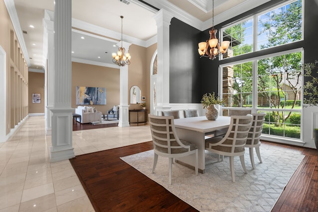 4609 Huffman Ct, Plano, TX 75093 - dining area featuring decorative columns, a chandelier, a towering ceiling, ornamental molding, and light tile patterned flooring