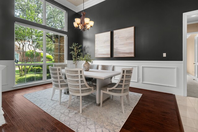4609 Huffman Ct, Plano, TX 75093 - dining room featuring crown molding, a chandelier, a wainscoted wall, healthy amount of natural light, and a decorative wall