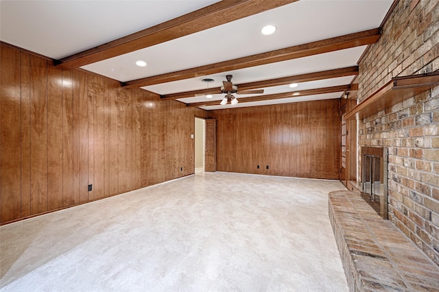 1013 Mountain Ter, Hurst, TX 76053 - unfurnished living room with beamed ceiling, a fireplace, a ceiling fan, wood walls, and light flooring