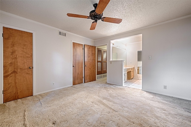 1013 Mountain Ter, Hurst, TX 76053 - unfurnished bedroom featuring a textured ceiling, crown molding, connected bathroom, light carpet, and ceiling fan