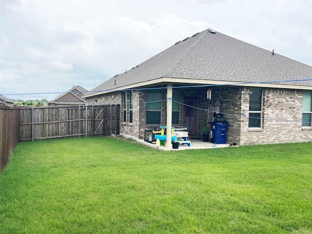 4107 Reese Ln, Krum, TX 76249 - rear view of house featuring brick siding, a patio area, roof with shingles, and a fenced backyard