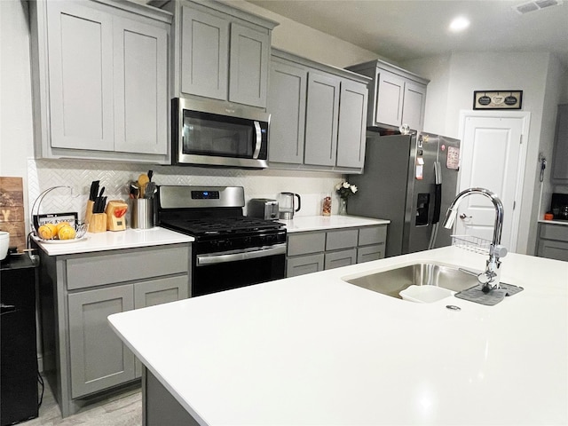 4107 Reese Ln, Krum, TX 76249 - kitchen with appliances with stainless steel finishes, gray cabinets, light countertops, and backsplash