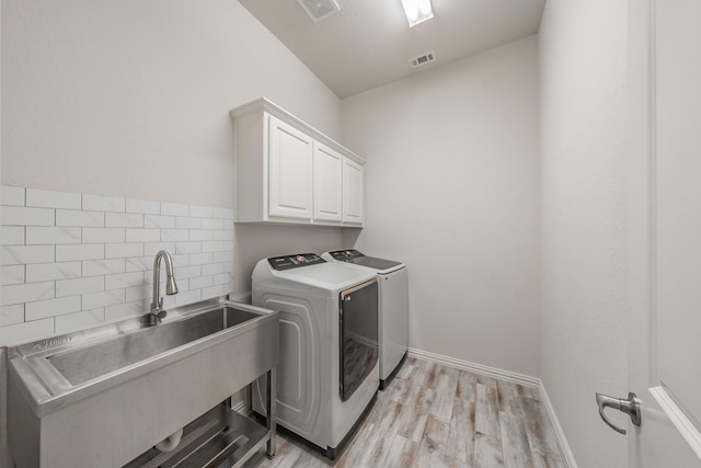 6340 Crossvine Trl, Flower Mound, TX 76226 - laundry area with washing machine and dryer, cabinet space, and light wood-type flooring
