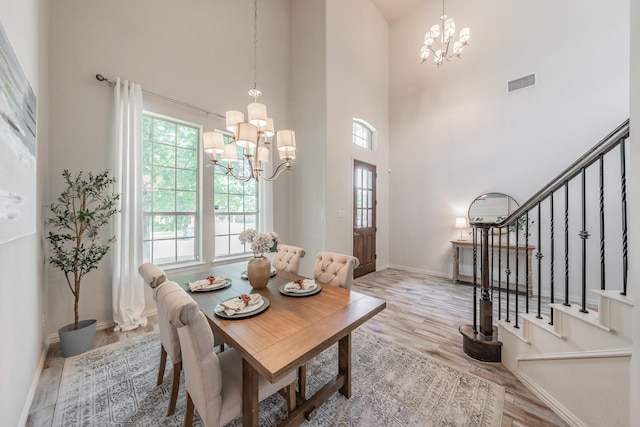 6340 Crossvine Trl, Flower Mound, TX 76226 - dining area featuring a chandelier, a towering ceiling, wood finished floors, and stairway