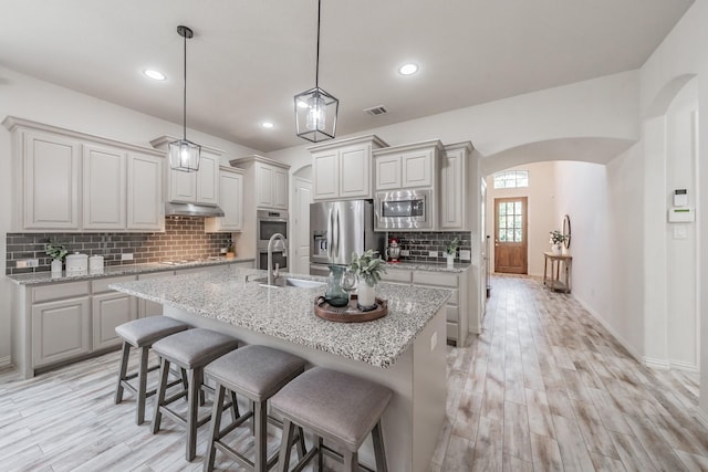 6340 Crossvine Trl, Flower Mound, TX 76226 - kitchen featuring stainless steel appliances, light wood finished floors, decorative backsplash, under cabinet range hood, and recessed lighting