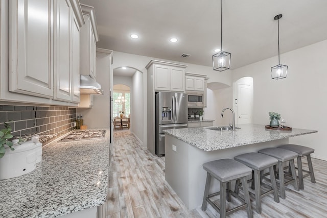 6340 Crossvine Trl, Flower Mound, TX 76226 - kitchen featuring stainless steel appliances, arched walkways, light wood-style floors, backsplash, and recessed lighting