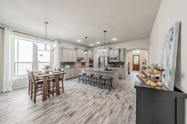 6340 Crossvine Trl, Flower Mound, TX 76226 - dining area with arched walkways, light wood finished floors, recessed lighting, and a chandelier