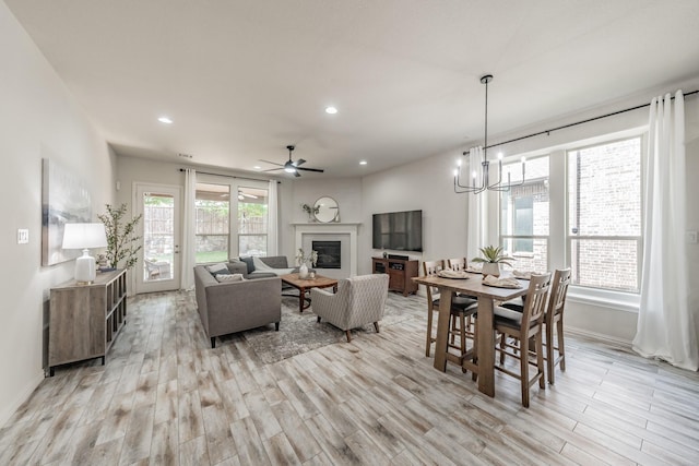 6340 Crossvine Trl, Flower Mound, TX 76226 - dining space with light wood-type flooring, a glass covered fireplace, ceiling fan, a chandelier, and recessed lighting