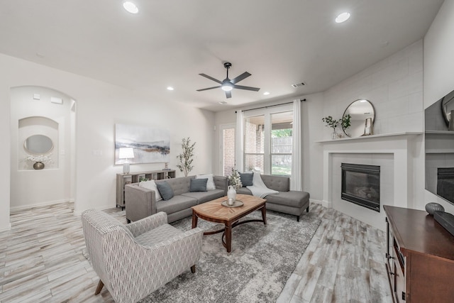 6340 Crossvine Trl, Flower Mound, TX 76226 - living area with a fireplace, light wood finished floors, a ceiling fan, recessed lighting, and arched walkways