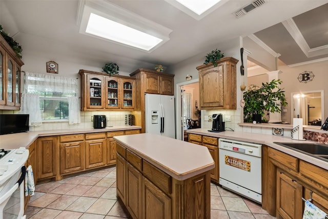 3001 Coventry Ln, Waxahachie, TX 75165 - kitchen with white appliances, backsplash, light countertops, glass insert cabinets, and crown molding