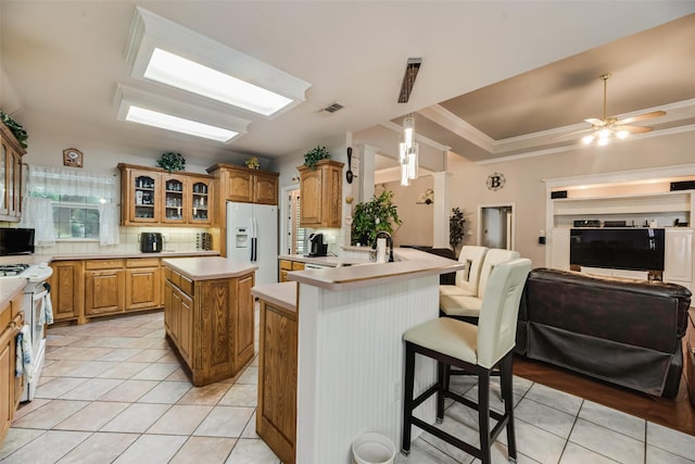 3001 Coventry Ln, Waxahachie, TX 75165 - kitchen with white appliances, glass insert cabinets, a kitchen bar, a center island, and backsplash
