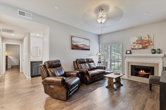 8601 Park Ln Unit 323, Dallas, TX 75231 - living room featuring light wood finished floors, a ceiling fan, a high end fireplace, and recessed lighting