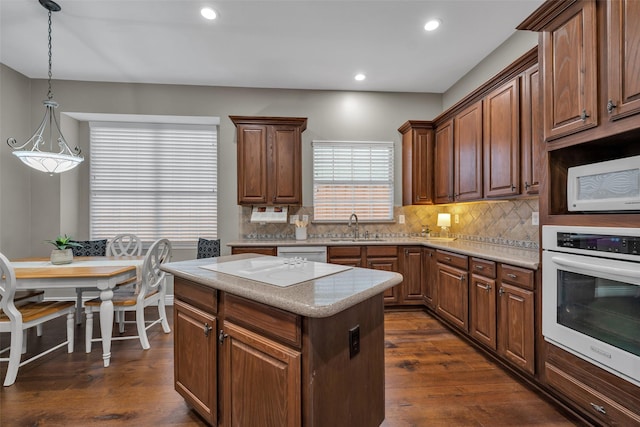 2413 London Dr, Plano, TX 75025 - kitchen featuring white appliances, dark wood finished floors, tasteful backsplash, a center island, and recessed lighting