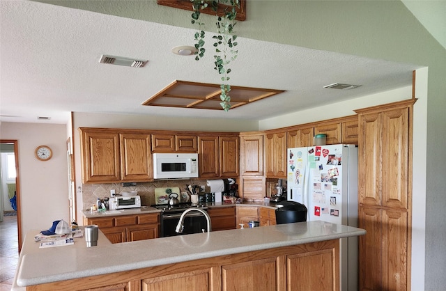 662 County Road 113, Whitesboro, TX 76273 - kitchen featuring white appliances, tasteful backsplash, brown cabinets, light countertops, and a textured ceiling