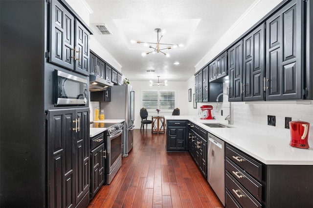 11721 Pine Creek Ct, Fort Worth, TX 76008 - kitchen with stainless steel appliances, a chandelier, dark wood-style flooring, light countertops, and under cabinet range hood