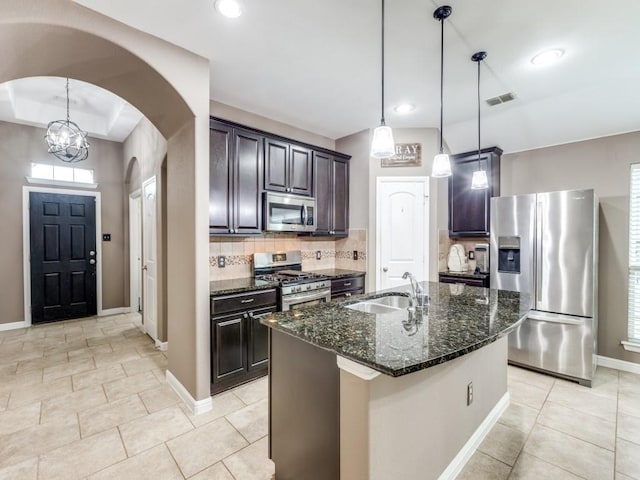 3107 Aspen Way, Melissa, TX 75454 - kitchen featuring stainless steel appliances, arched walkways, dark stone countertops, backsplash, and light tile patterned floors