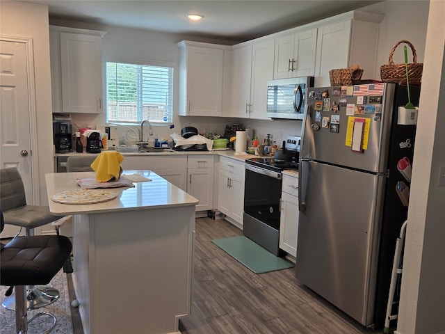 1201 Autumn Mist Ln, Forney, TX 75126 - kitchen with stainless steel appliances, light countertops, wood finished floors, white cabinetry, and recessed lighting