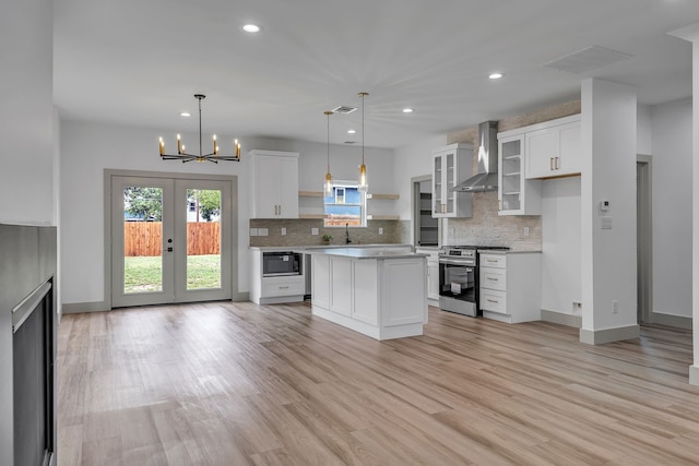 3709 Colonial Ave, Dallas, TX 75215 - kitchen featuring stainless steel range, wall chimney range hood, black microwave, healthy amount of natural light, and recessed lighting