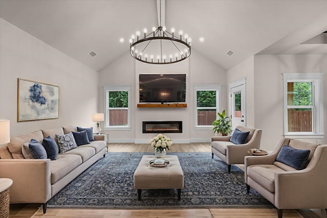 5822 Diaz Ave, Fort Worth, TX 76107 - living area featuring a chandelier, wood finished floors, high vaulted ceiling, and a glass covered fireplace