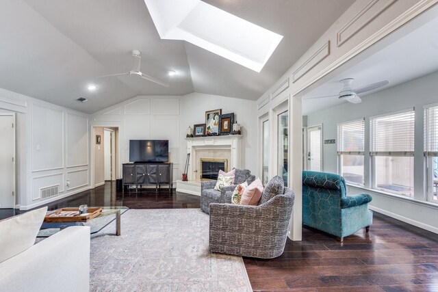 2313 Parkhaven Dr, Plano, TX 75075 - living area featuring ceiling fan, a skylight, wood finished floors, a glass covered fireplace, and lofted ceiling