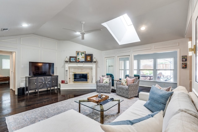 2313 Parkhaven Dr, Plano, TX 75075 - living room with lofted ceiling, wood finished floors, a skylight, a glass covered fireplace, and ceiling fan