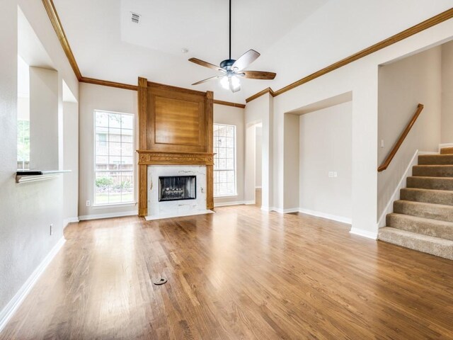 564 Austin Ct, Coppell, TX 75019 - unfurnished living room featuring arched walkways, ceiling fan, light wood finished floors, a premium fireplace, and crown molding