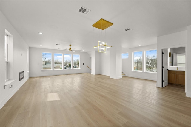 3434 Puget St, Dallas, TX 75212 - unfurnished living room featuring plenty of natural light, light wood finished floors, heating unit, a ceiling fan, and recessed lighting