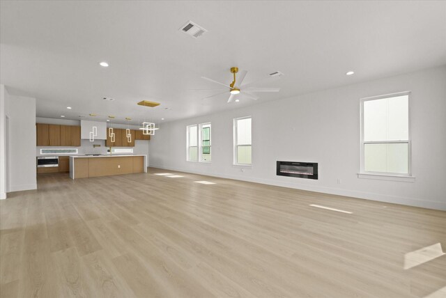 3434 Puget St, Dallas, TX 75212 - unfurnished living room featuring light wood-type flooring, recessed lighting, a ceiling fan, a glass covered fireplace, and heating unit