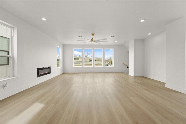 3434 Puget St, Dallas, TX 75212 - unfurnished living room with recessed lighting, a glass covered fireplace, light wood-style flooring, and a ceiling fan