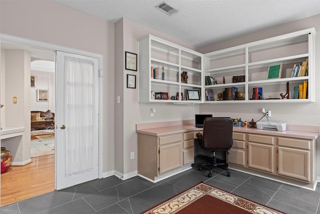 2114 Hunter Place Ln, Arlington, TX 76006 - office with built in study area, dark tile patterned flooring, and a textured ceiling